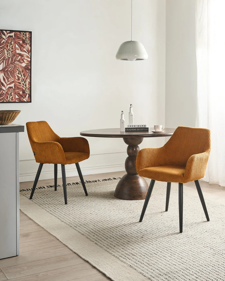 Modern mustard orange dining chairs styled around a dark wood table in a cozy contemporary dining room.