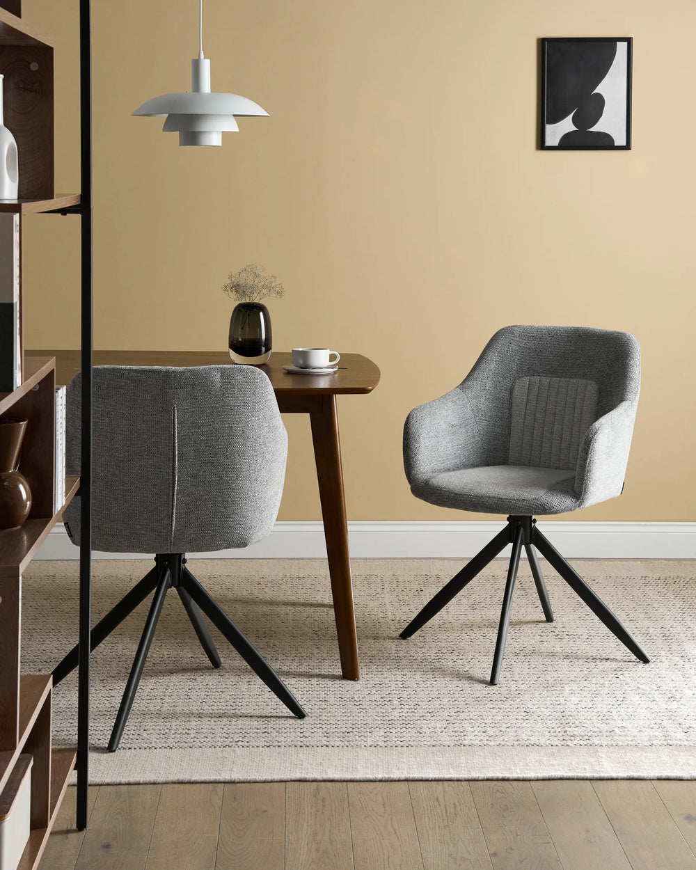 Modern dining setting showcasing the chair’s soft grey upholstery, swivel design, and contemporary black metal base.
