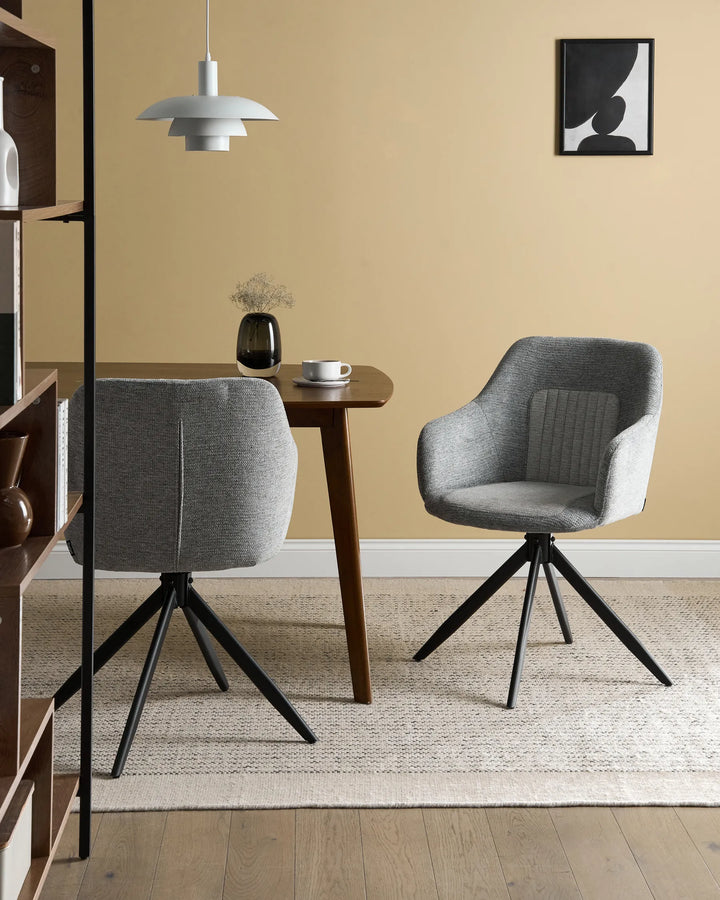 Modern dining setting showcasing the chair’s soft grey upholstery, swivel design, and contemporary black metal base.