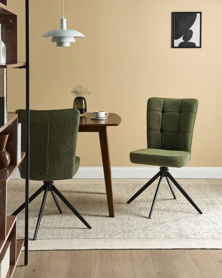 Dark green bouclé swivel dining chairs around a walnut dining table with a black glass vase, white coffee cup, modern white pendant light, shelving unit, framed abstract wall art, and a textured cream rug in a contemporary dining room.