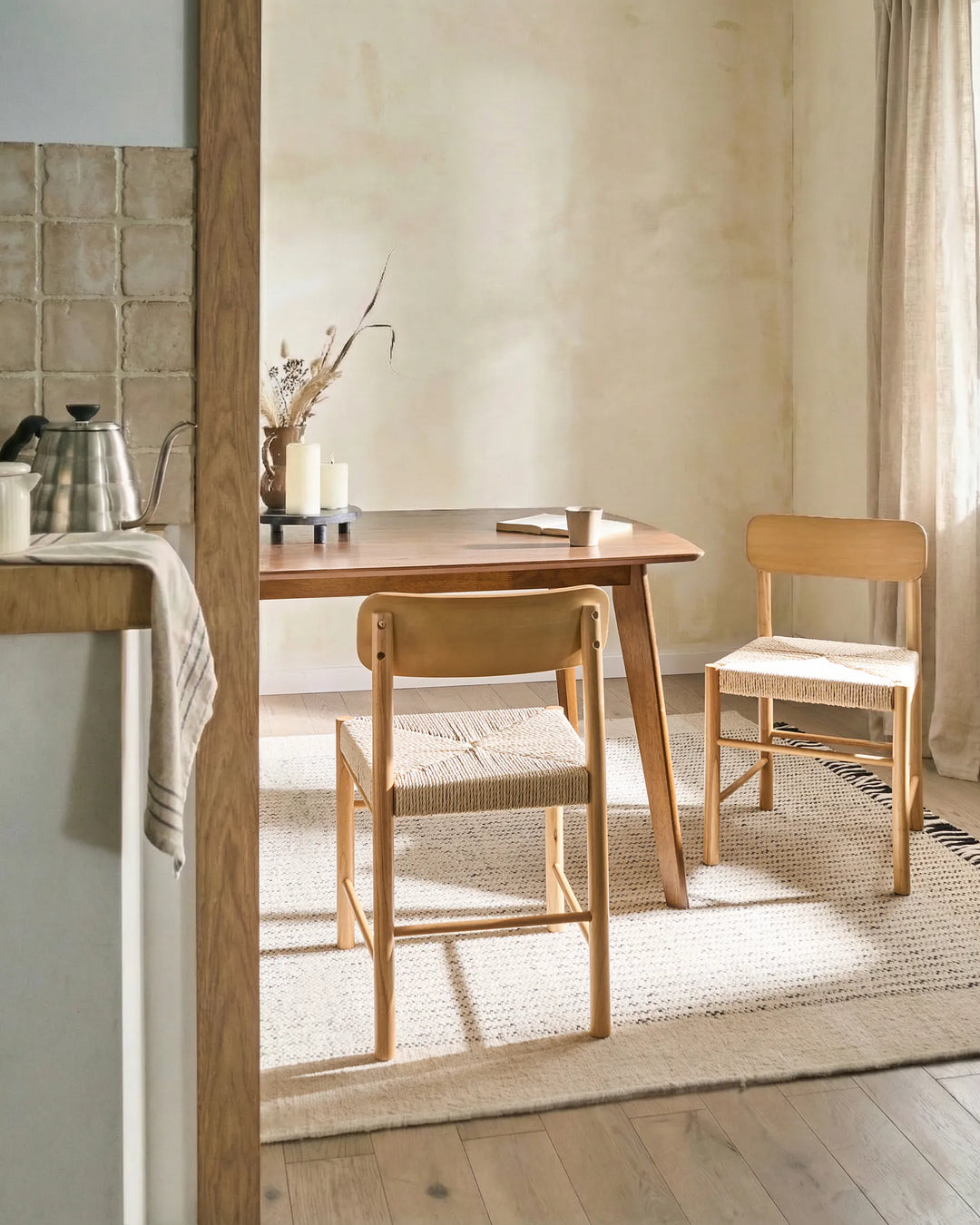 Natural wood woven-seat dining chairs styled in a warm, organic dining space with soft neutral tones, textured textiles, and minimalist décor, creating a cozy Scandinavian-inspired and earthy atmosphere.