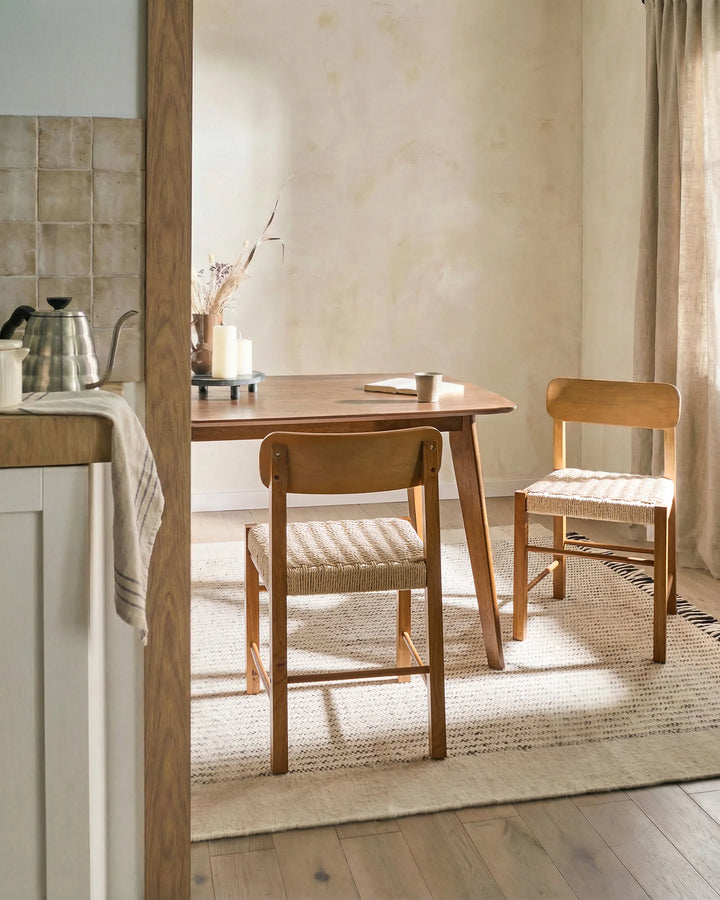 Natural wood woven dining chairs styled in a warm, cozy dining setting with soft neutral tones and organic finishes, creating a relaxed, inviting, and timeless atmosphere.