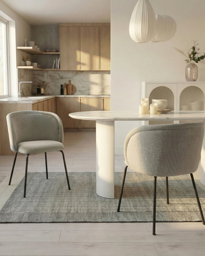 Cream dining chairs styled around a modern marble dining table in a bright, minimalist dining space.