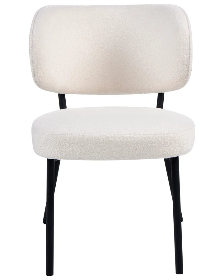 Modern dining chair upholstered in soft off-white boucle fabric, featuring a curved backrest, padded seat, and sleek black metal legs.