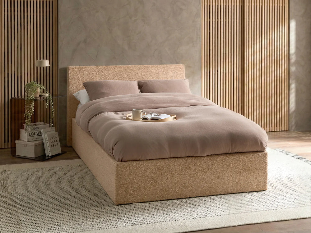 Beige bed with brown bedding in a modern bedroom setting