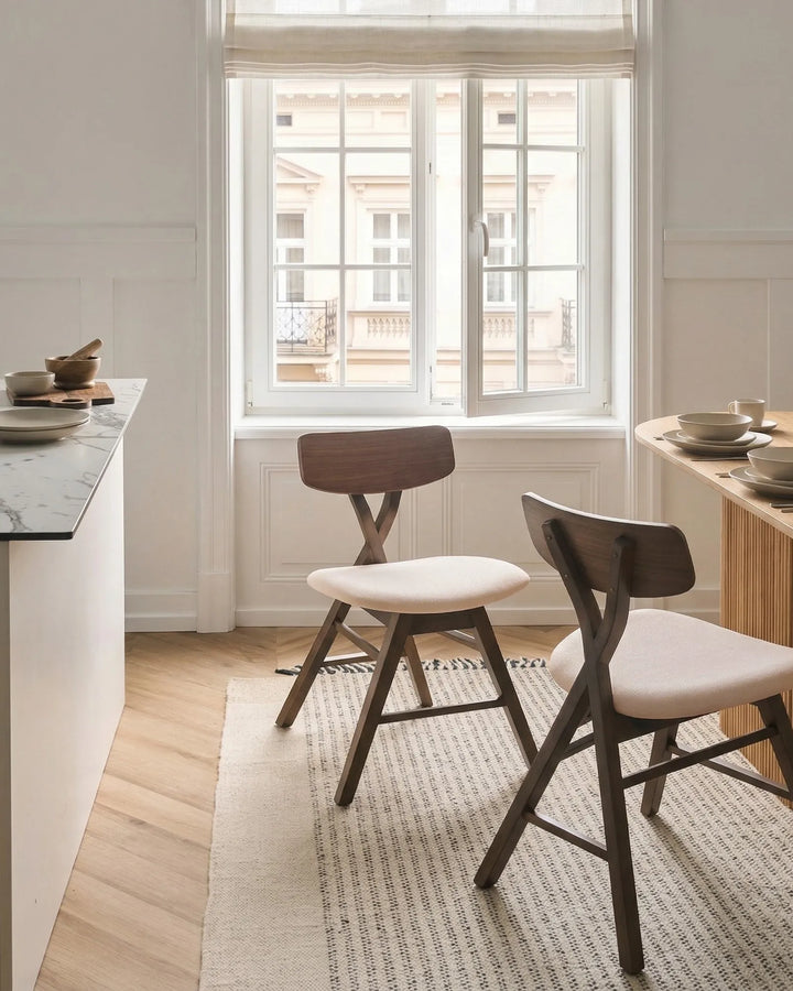 Walnut dining chairs styled in a bright, airy dining setting with soft neutral tones, bringing warmth, sophistication, and a cozy modern feel to the space.
