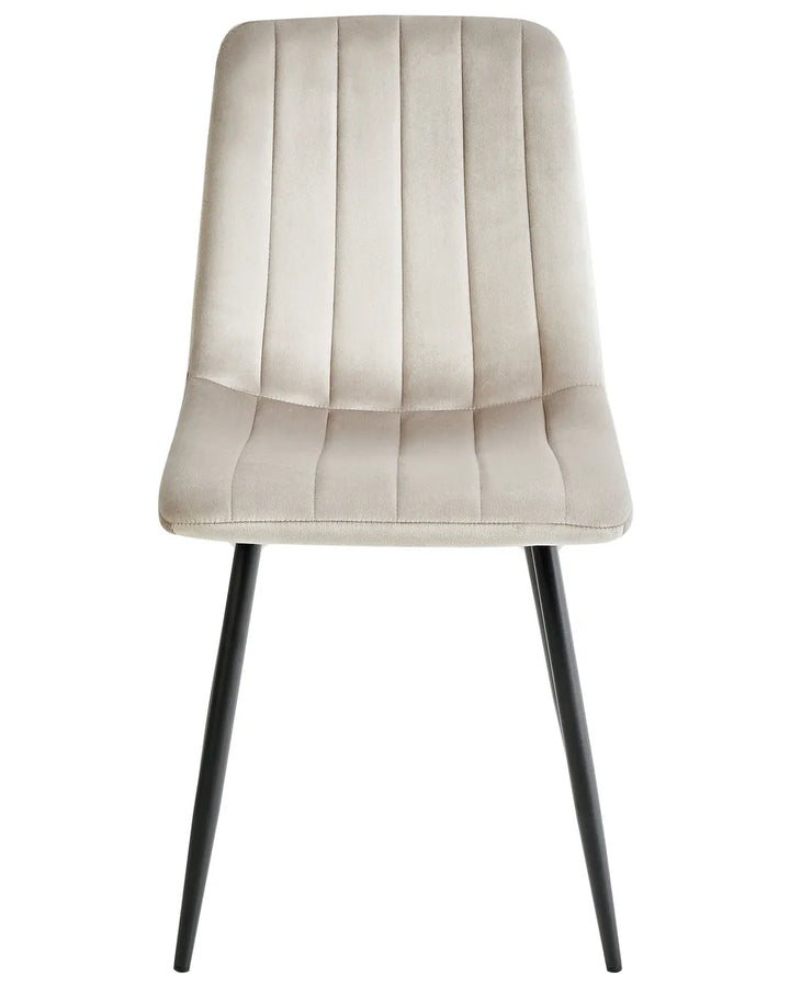 Beige velvet dining chair with vertical channel stitching and sleek black metal legs.
