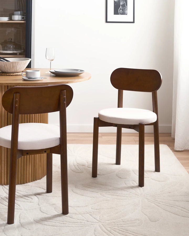 Rich walnut dining chairs styled in a cozy neutral dining setting, adding warmth and understated elegance through soft textures, natural wood tones, and a timeless contemporary feel.