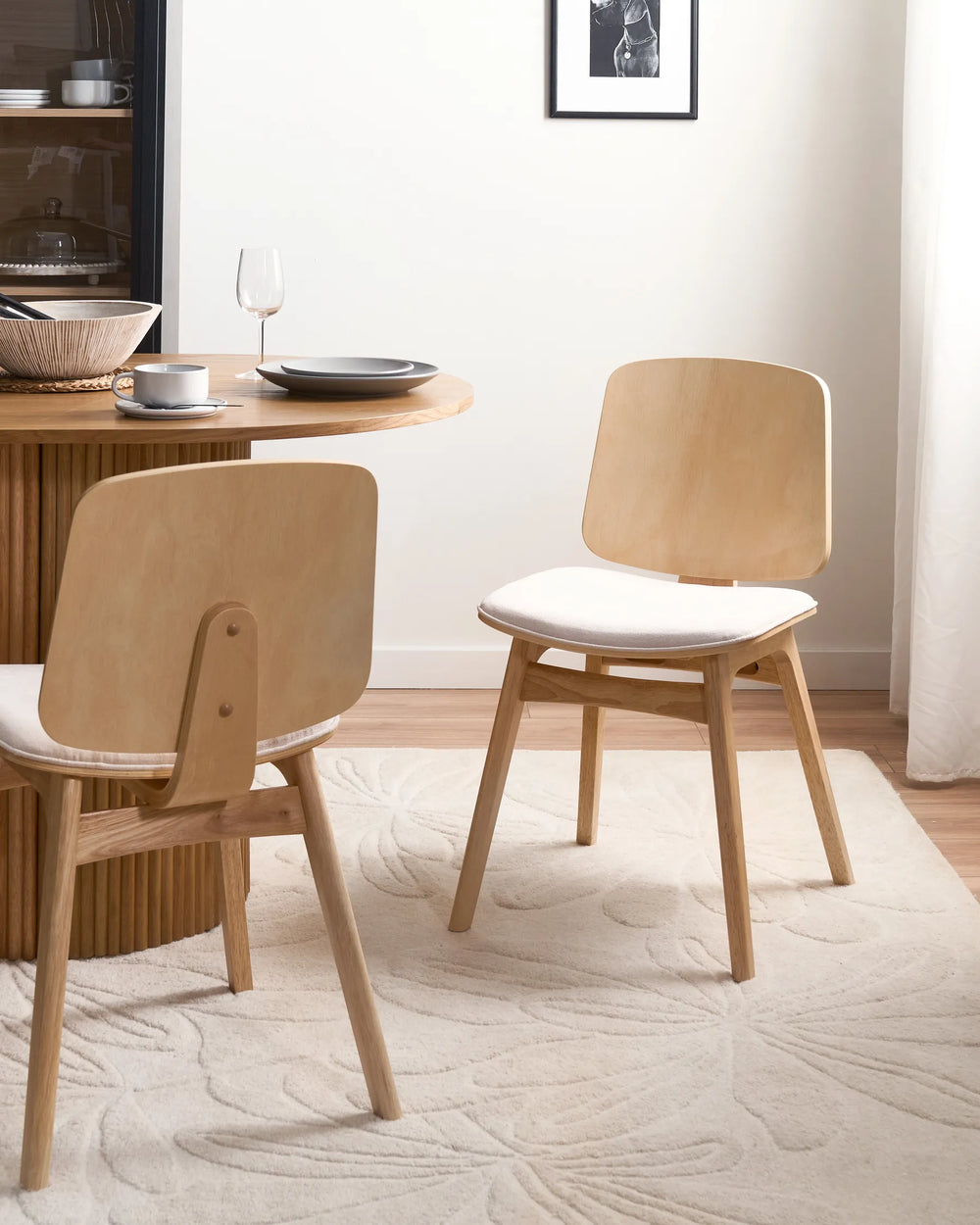 Light wood dining chairs styled around a warm, modern dining table, creating a bright, airy, and minimalist space with soft neutral tones and natural textures.