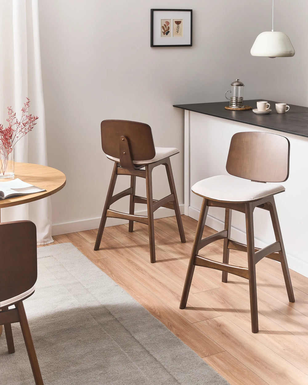 Walnut counter stools styled in a clean, contemporary kitchen space, pairing rich wood tones and soft upholstery for a warm, inviting, and minimalist dining atmosphere.