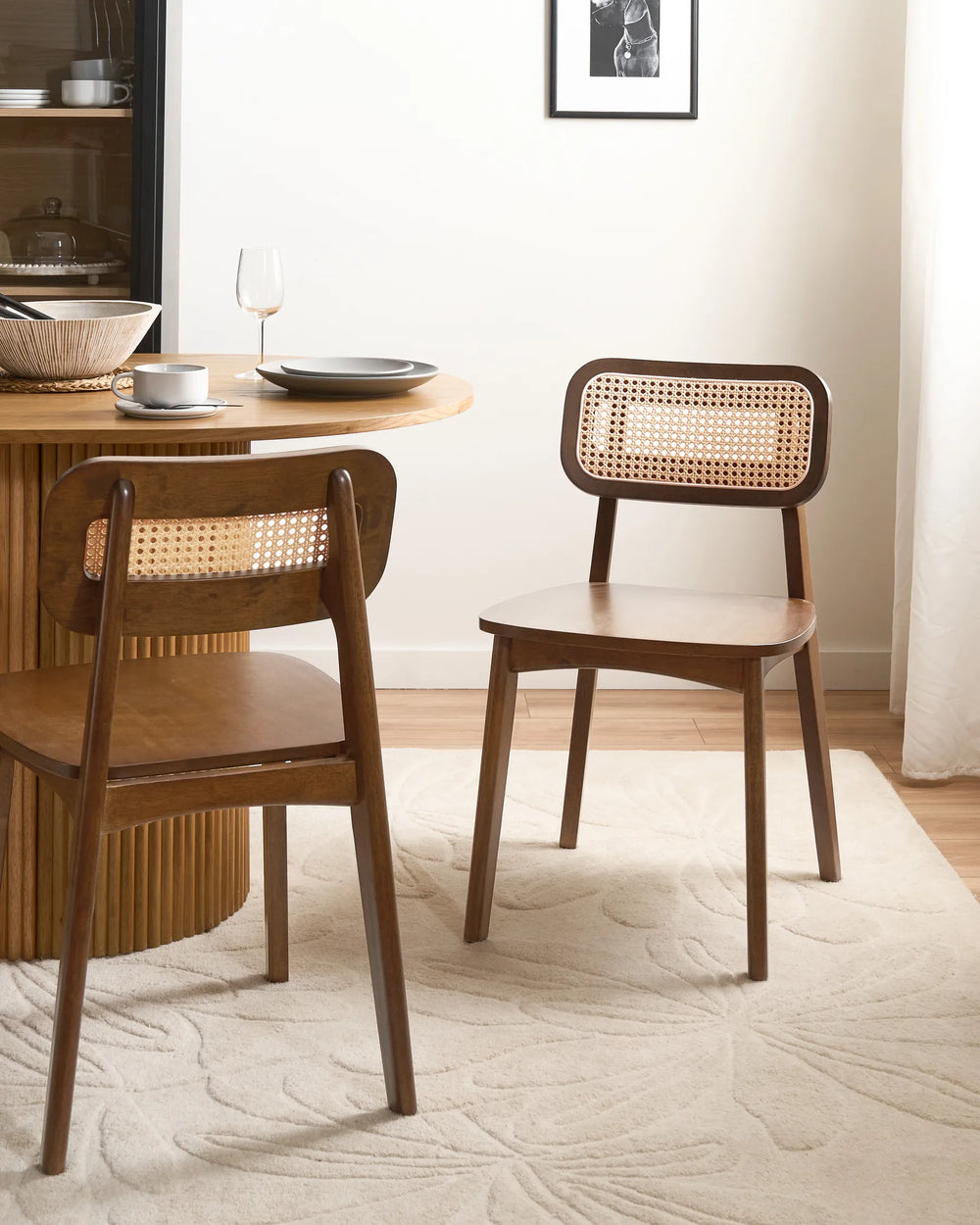Dark wood rattan dining chairs styled in a bright, modern dining space, creating a warm and sophisticated atmosphere with organic textures, soft neutrals, and cozy contemporary appeal.
