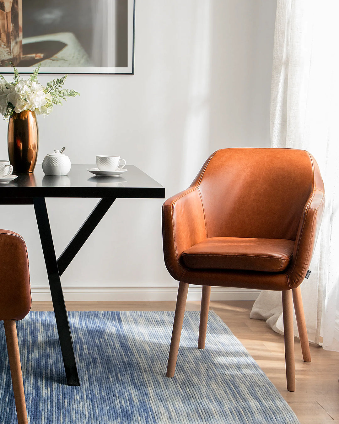 Warm and inviting dining space featuring brown faux leather chairs, wooden accents, and soft natural light for a sophisticated modern look.