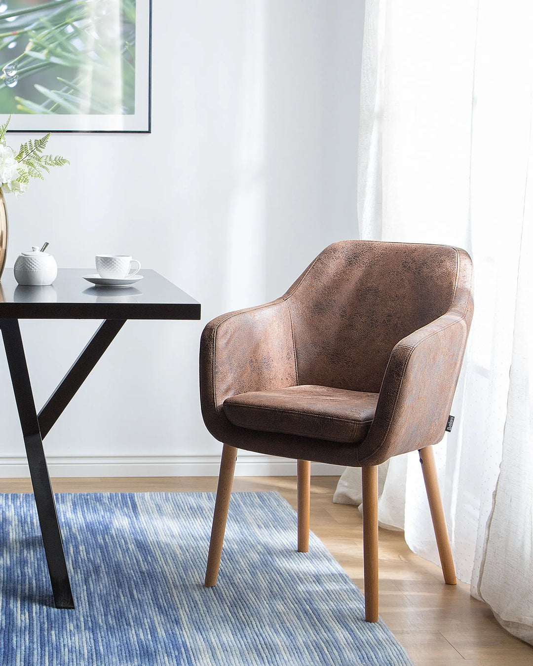 Elegant dining setting showcasing a vintage-inspired brown armchair paired with light wood accents and soft natural lighting.