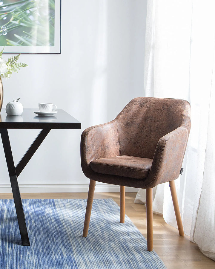 Elegant dining setting showcasing a vintage-inspired brown armchair paired with light wood accents and soft natural lighting.