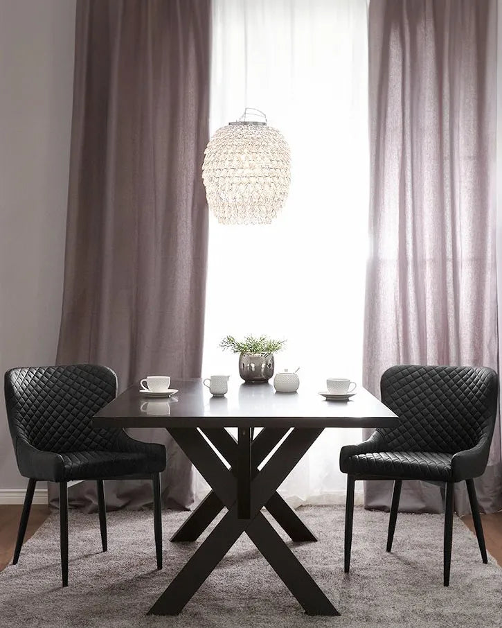 Elegant dining setup featuring black quilted chairs and a matching black table, creating a modern and luxurious atmosphere.