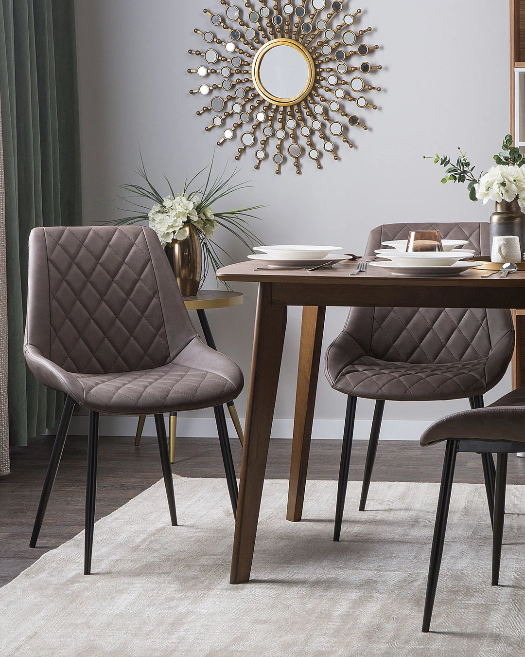 Stylish dining space featuring grey quilted chairs paired with a wooden table, creating a contemporary and inviting atmosphere.