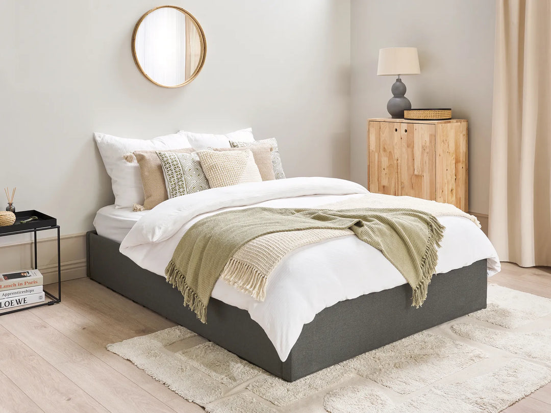 Modern bedroom with a bed, nightstands, and decor items.
