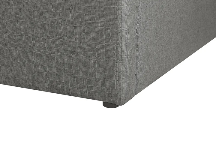 Gray upholstered corner piece with a visible leg on a white background