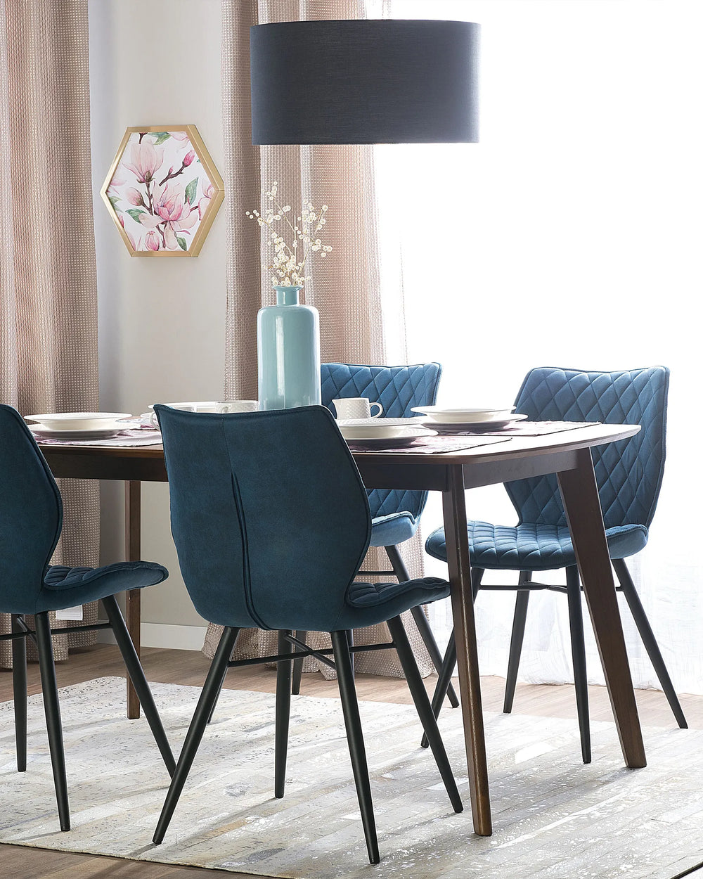 Blue velvet dining chairs arranged around a dark wood dining table, bringing a sophisticated contemporary look to the dining room.