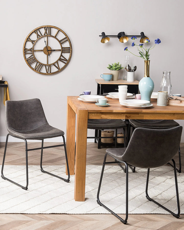 Modern dining area featuring grey upholstered chairs paired with a natural wood table, creating a balanced look with industrial and contemporary elements.