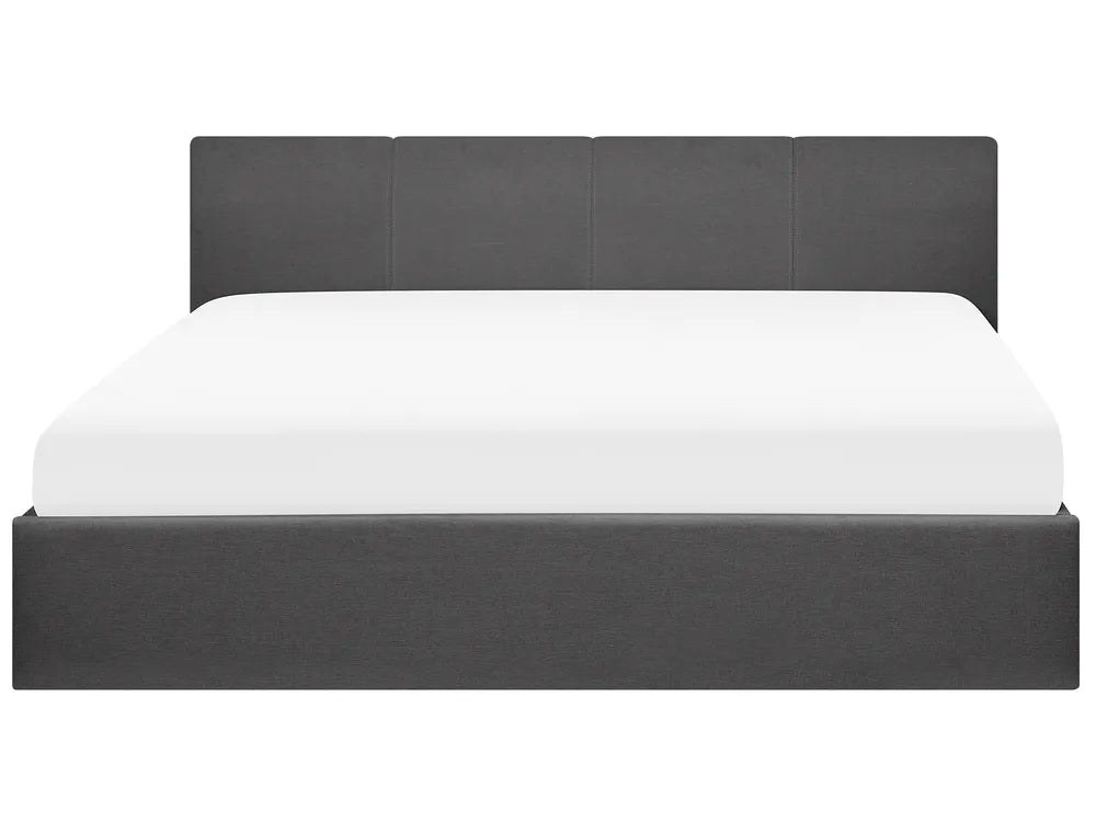 Bed with dark upholstered headboard and white mattress 
