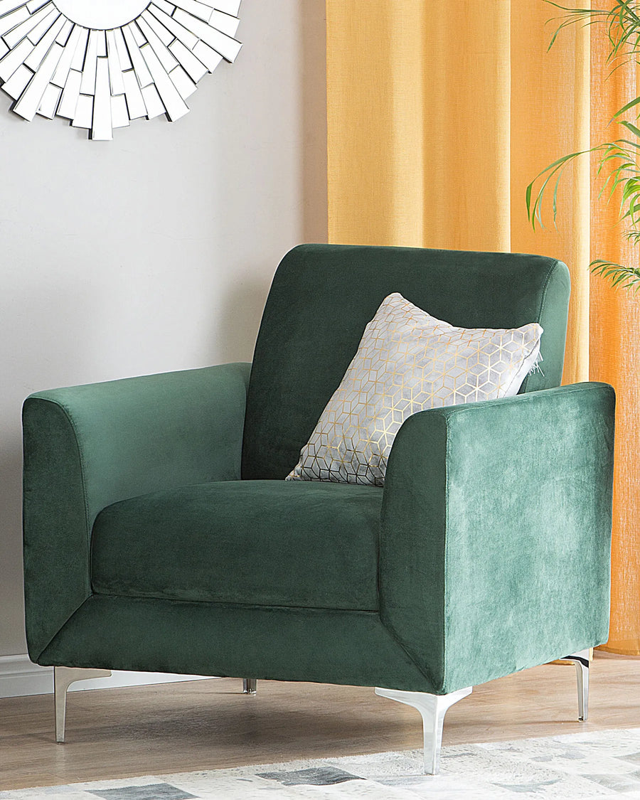 Green armchair with a decorative pillow in a room with orange curtains and a mirror.