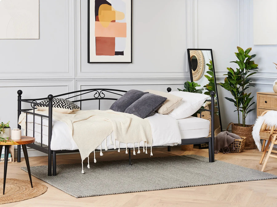 Bedroom with a black metal bed frame, white bedding, and decorative pillows.