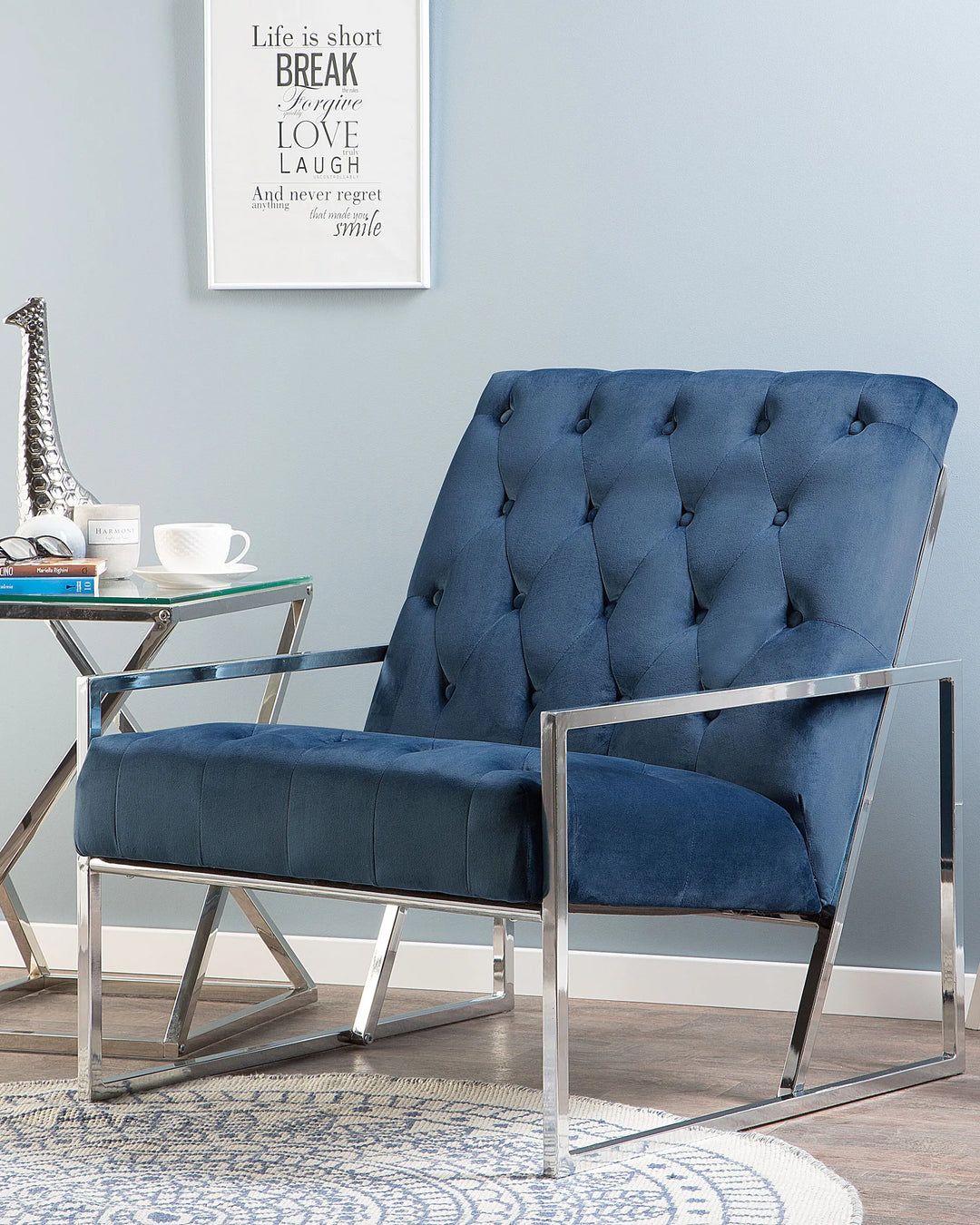 Blue armchair with chrome frame in a room with a motivational poster on the wall.