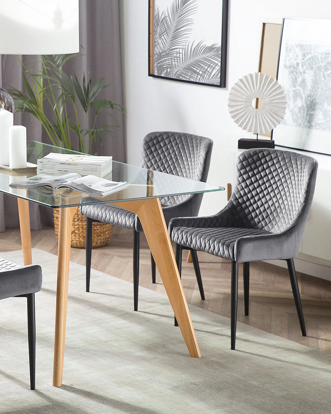 Grey quilted dining chairs paired with a glass-top table in a stylish modern dining room.
