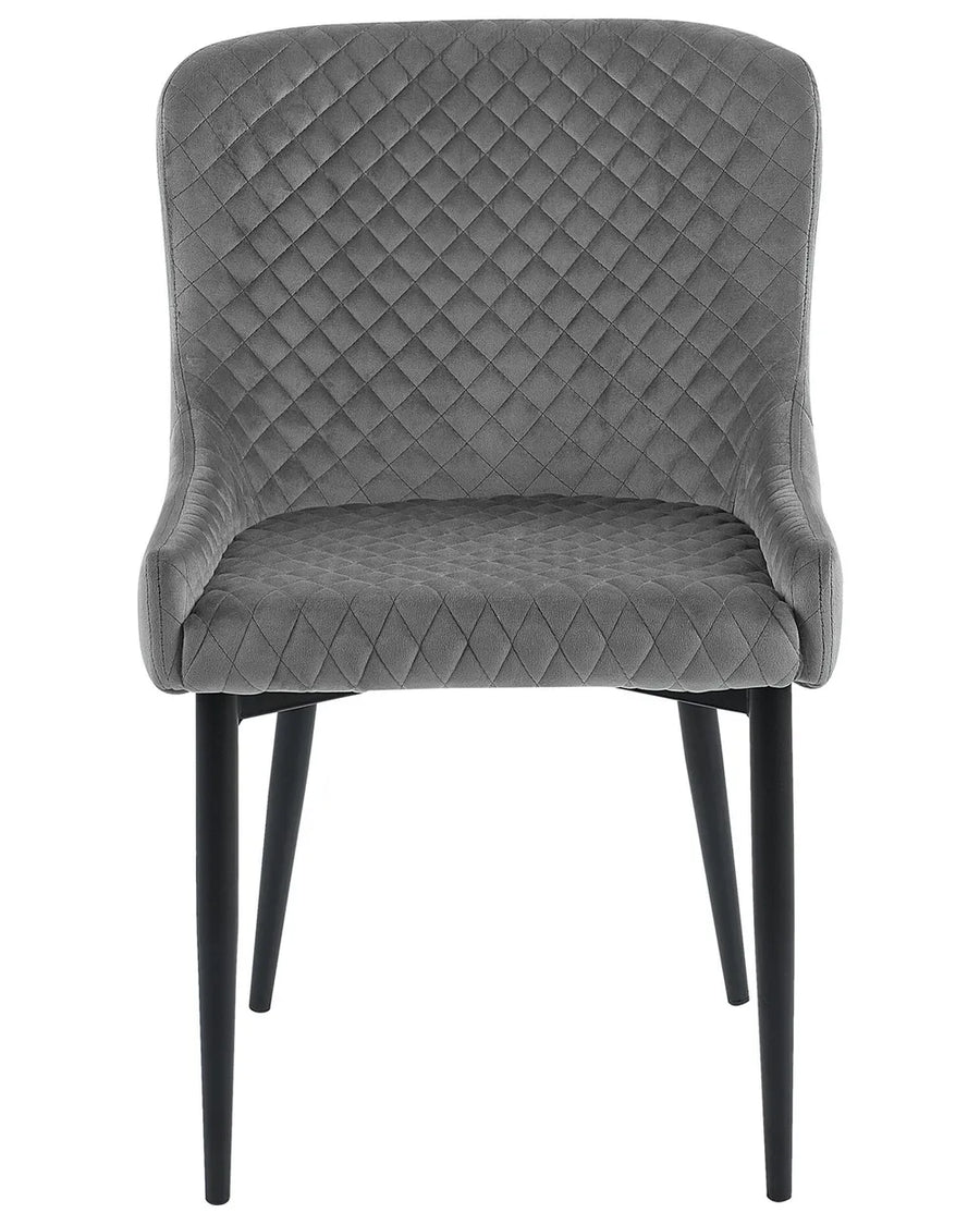 Grey velvet dining chair with diamond quilting, curved armrests, and black metal legs.