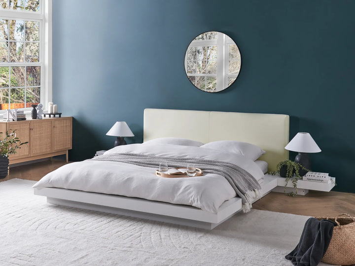 Modern bedroom with a bed, nightstands, and decorative items.