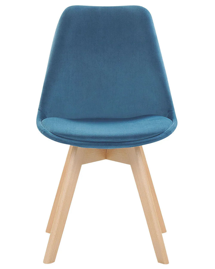 Blue velvet dining chair with a softly curved silhouette and natural wood legs, blending comfort with Scandinavian-inspired design.