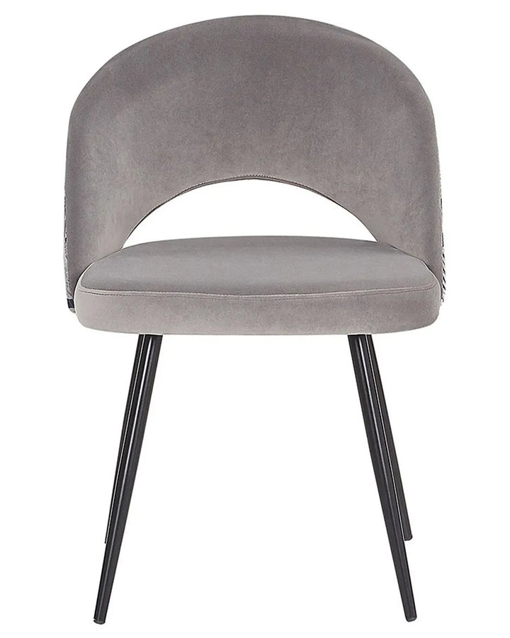 Grey velvet dining chair with black legs.