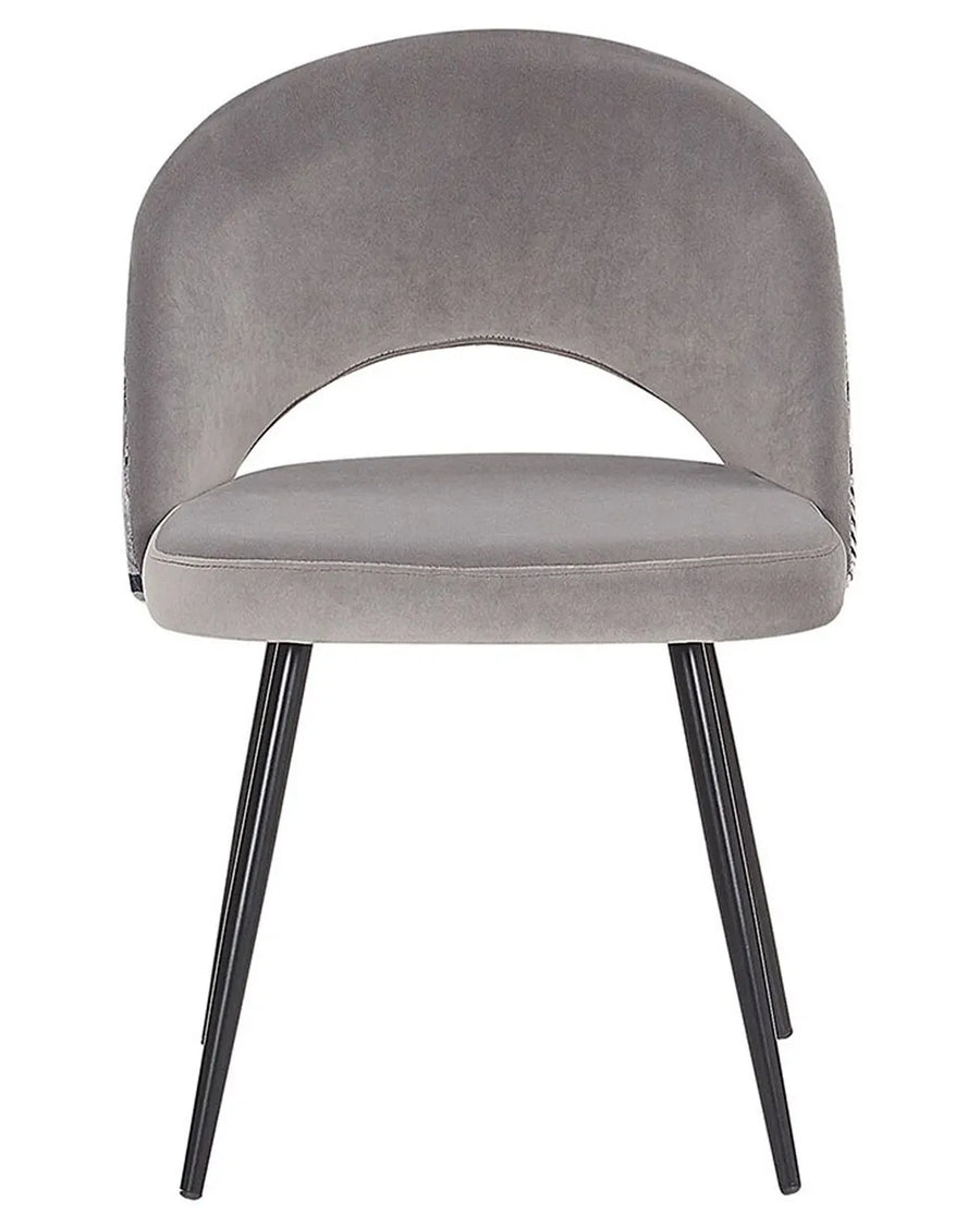 Grey velvet dining chair with black legs.