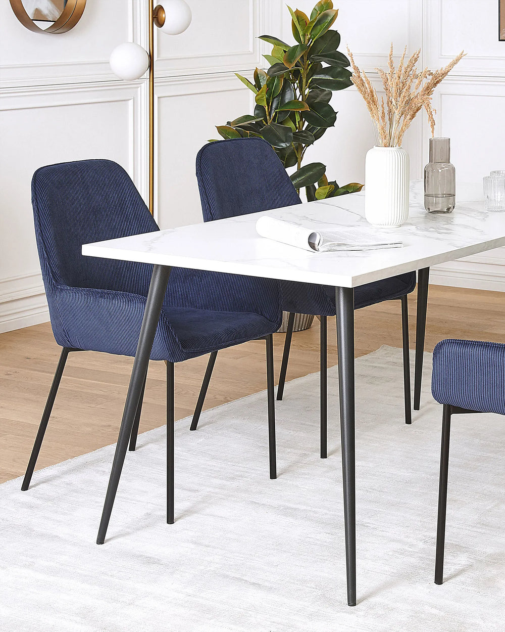 Contemporary dining area styled with navy corduroy chairs, adding texture, comfort, and a sophisticated touch to the space.