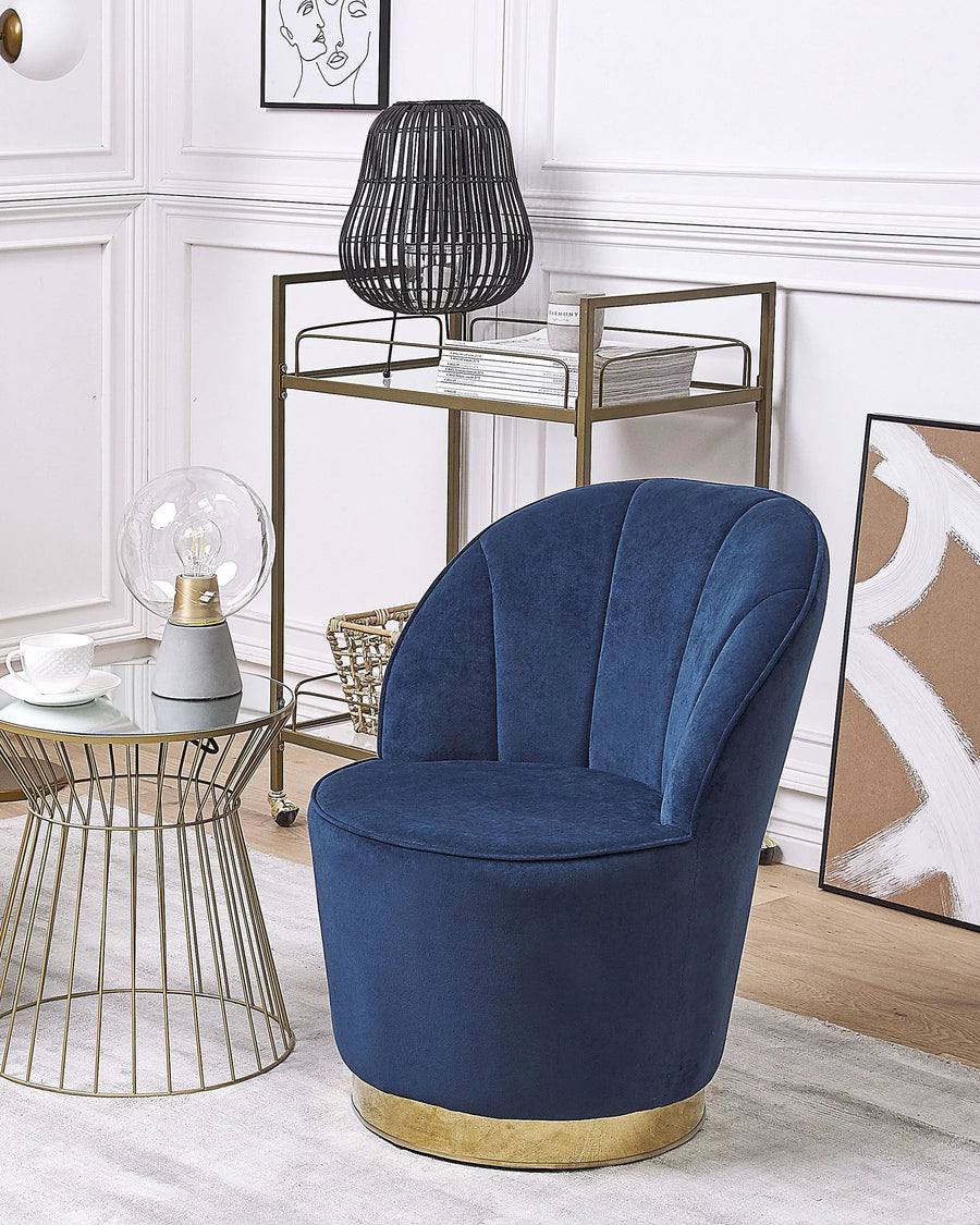 Blue velvet chair in a stylish living room with decorative elements.