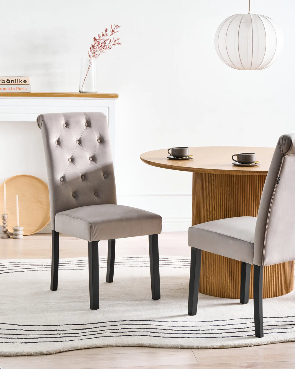Elegant tufted dining chairs paired with a round wooden table, creating a warm and sophisticated dining room setting.