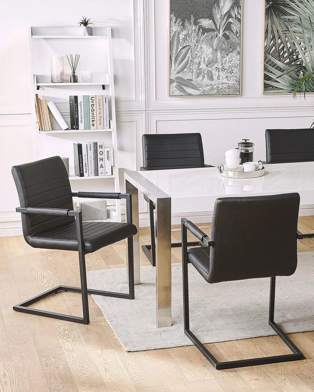 Styled around a glossy dining table, these black cantilever dining chairs create a sophisticated modern setting, combining clean lines, minimalist design, and comfortable seating for everyday dining and entertaining.