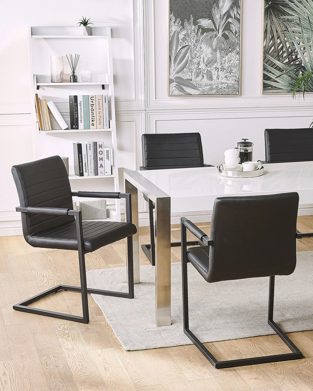 Styled around a glossy dining table, these black cantilever dining chairs create a sophisticated modern setting, combining clean lines, minimalist design, and comfortable seating for everyday dining and entertaining.