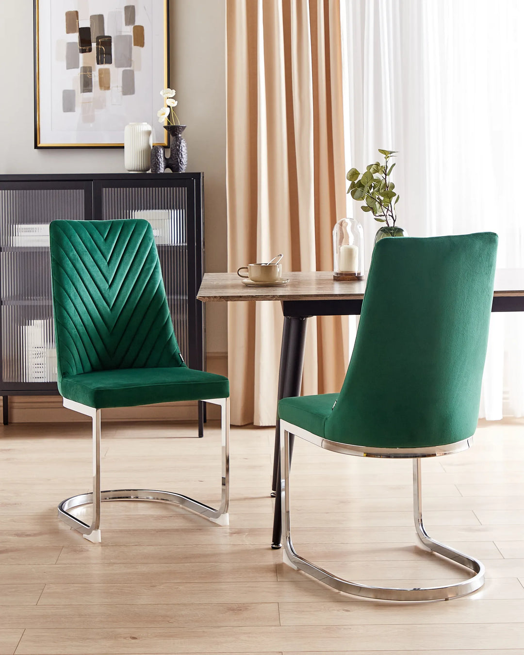 Green velvet dining chairs around a wooden dining table.