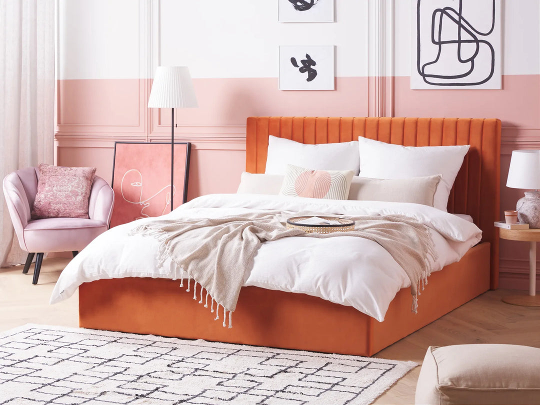Modern bedroom with orange bed, pink walls, and decorative elements.