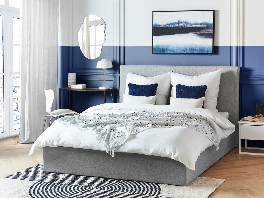 Grey upholstered bed with white bedding 