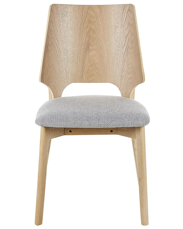 Contemporary dining chair featuring a sculptural two-tone wood backrest, light oak-effect frame, and a generously padded grey fabric seat. The distinctive geometric silhouette combines modern craftsmanship with everyday comfort, making it an elegant addition to dining rooms, kitchens, and open-plan living spaces.