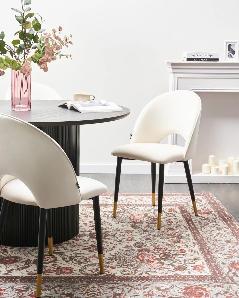 Elegant cream dining chairs styled around a black round dining table for a refined modern dining space.