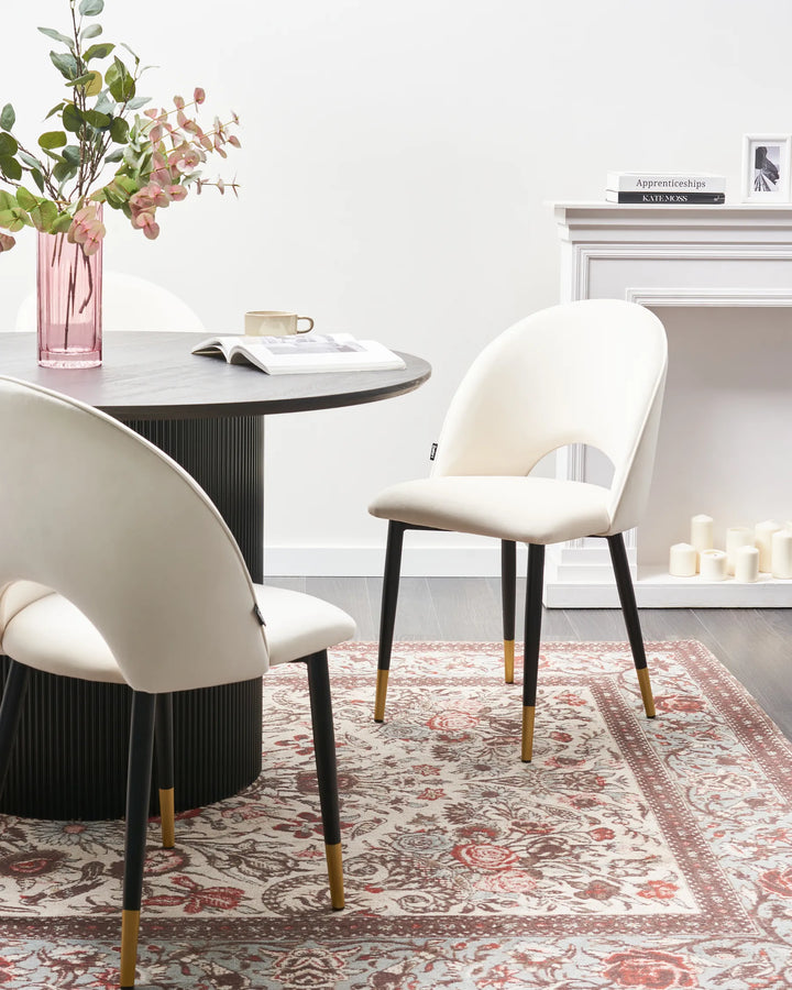Elegant cream dining chairs styled around a black round dining table for a refined modern dining space.