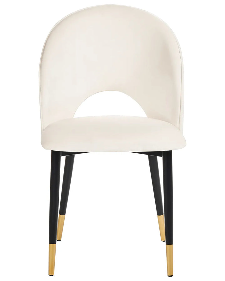 Cream upholstered dining chair with a curved backrest, cut-out detail, and black legs with gold accents.
