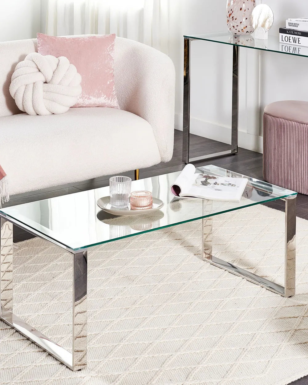 Modern living room with glass coffee table, white sofa, and pink accents.