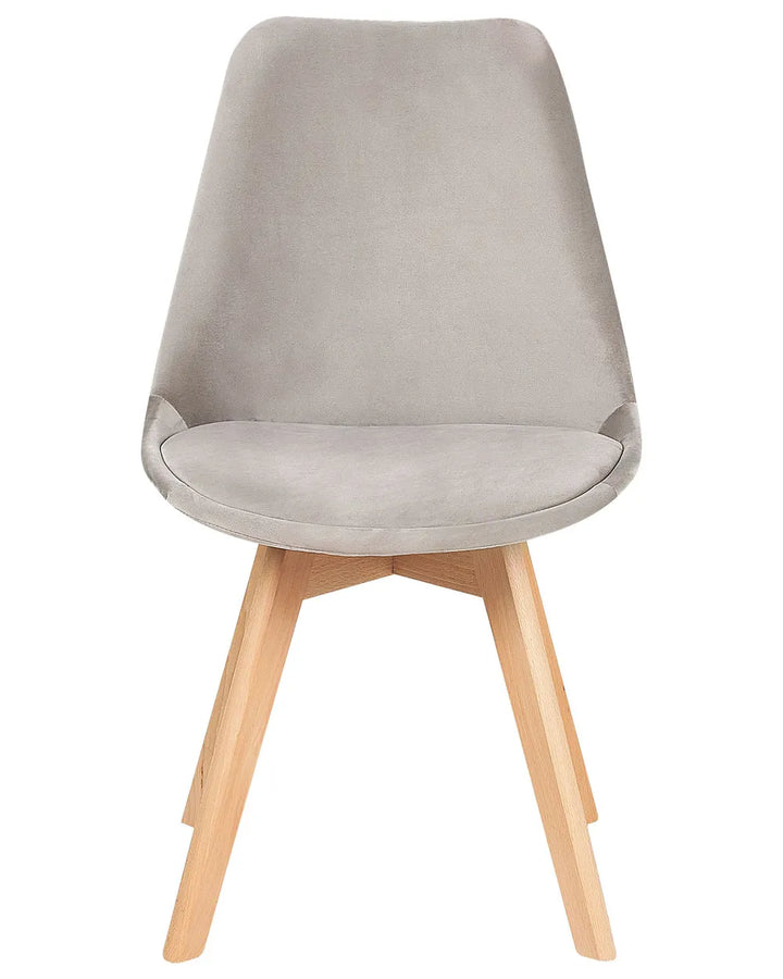 Grey velvet dining chair with a curved seat and natural wood legs for a soft, modern look.
