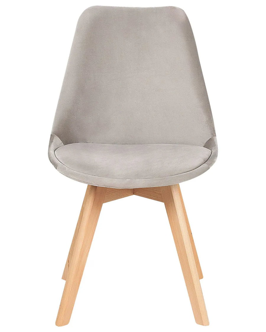 Grey velvet dining chair with a curved seat and natural wood legs for a soft, modern look.