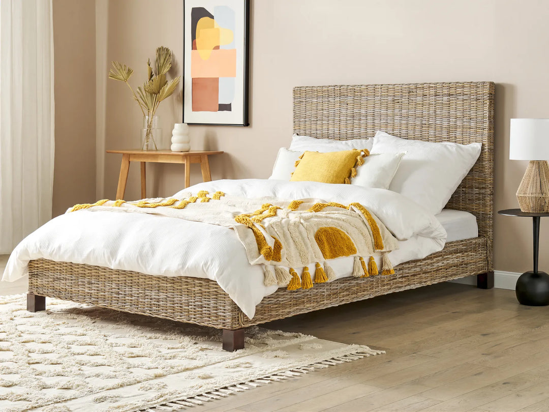Bedroom with a wicker bed, white bedding, and yellow accents.